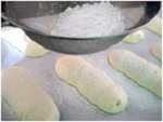 Отсаженные печенья савоярди перед выпечкой - посыпка сахарной пудрой