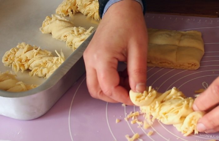 Заворачиваем полоски сдобного теста для булочек в виде жгута - формовка сдобных дрожжевых сырных булочек